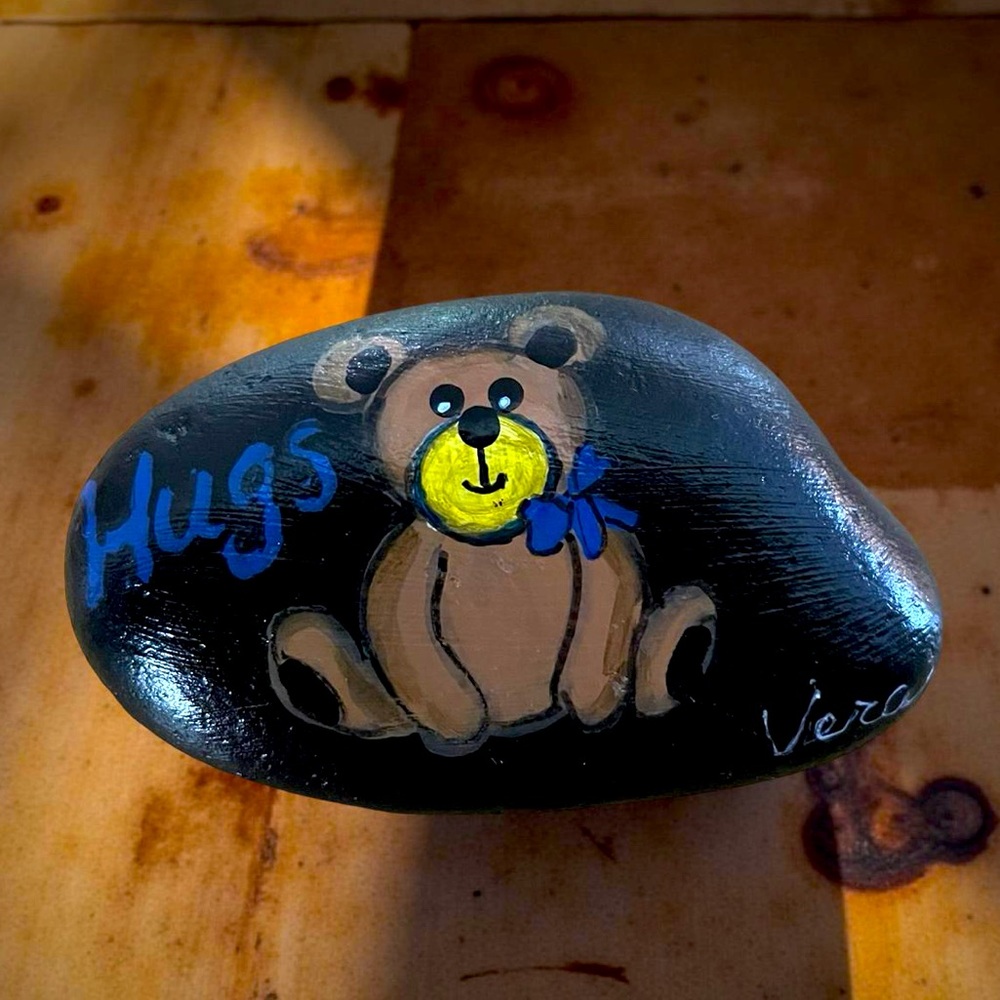 Hand crafted painted brown Teddy Bear rock sitting black stone blue bow HUGS